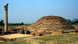 A life size-pillar beside a brick stupa  commemorates Buddha`s last sermon and announcement of his approaching nirvana 